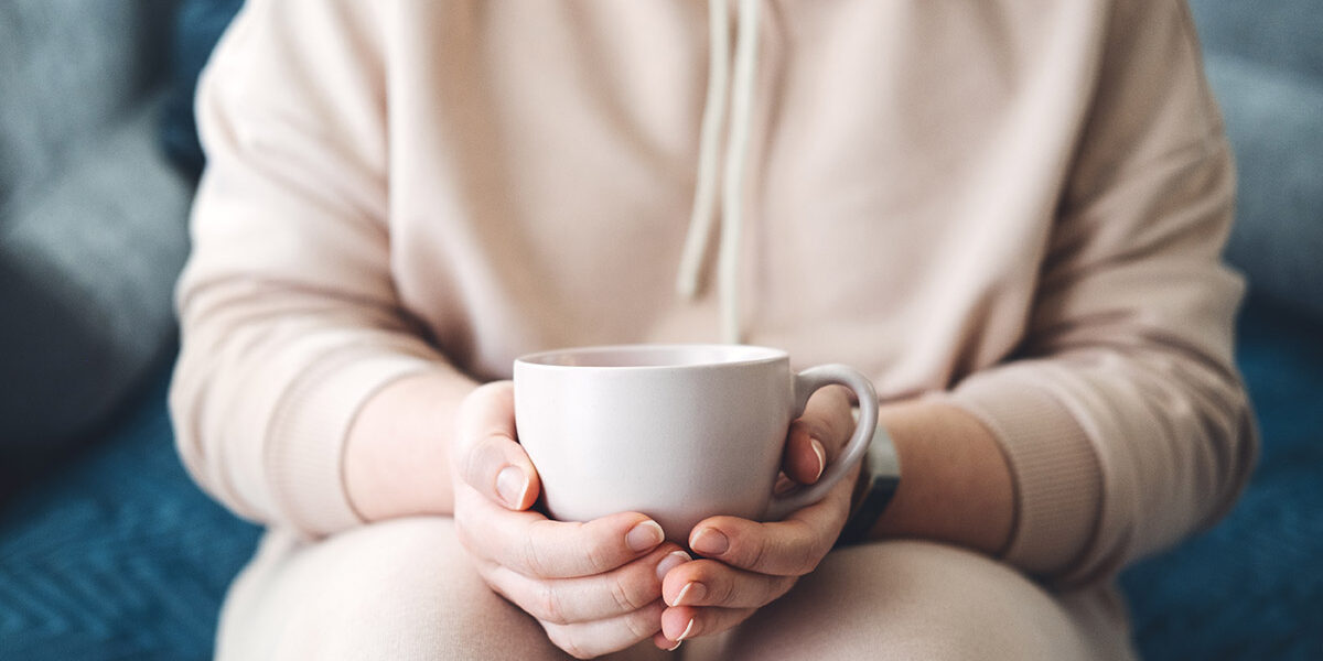 femme tenant une tasse de café