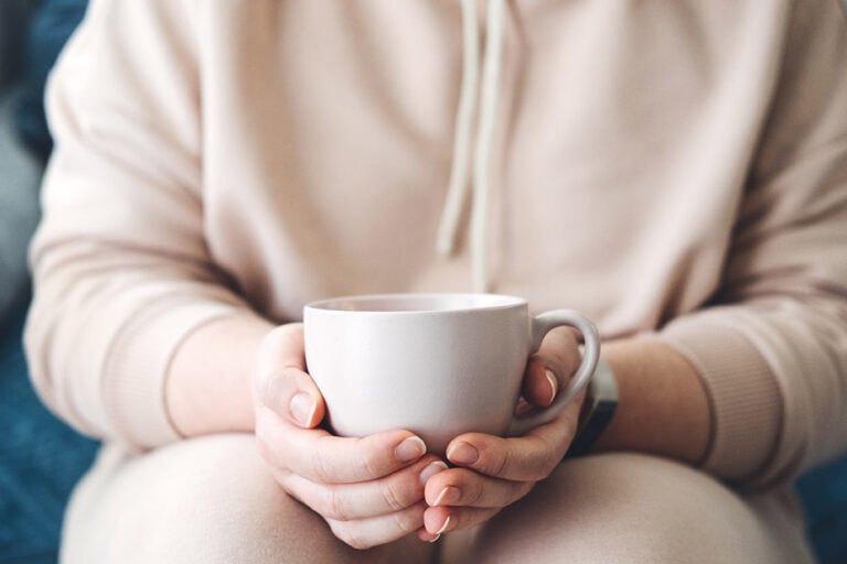 femme tenant une tasse de café